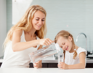 mother pouring glass of water for child