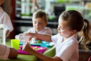 school girl pouring cup of water