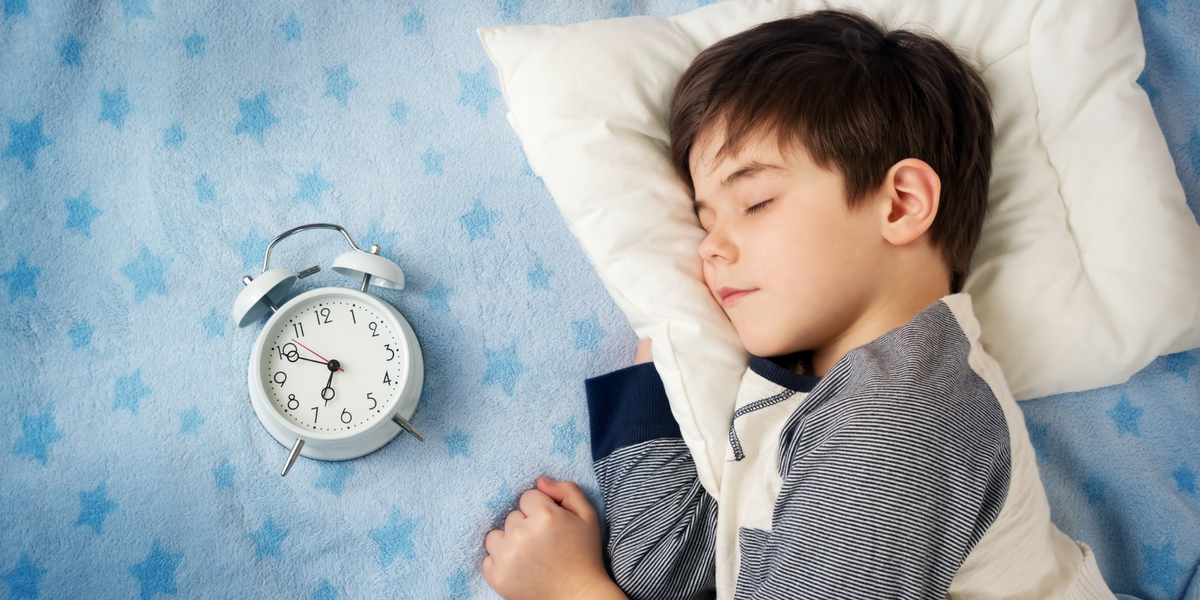 little boy in bed with clock