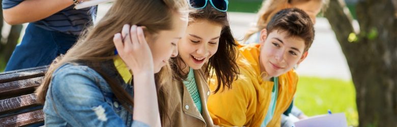 young teenage students sat on bench