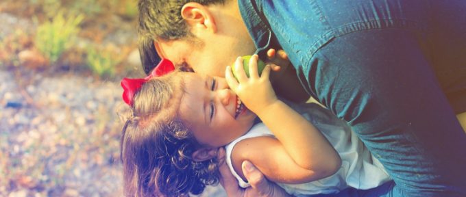 father hugging child smiling
