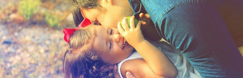 father hugging child smiling