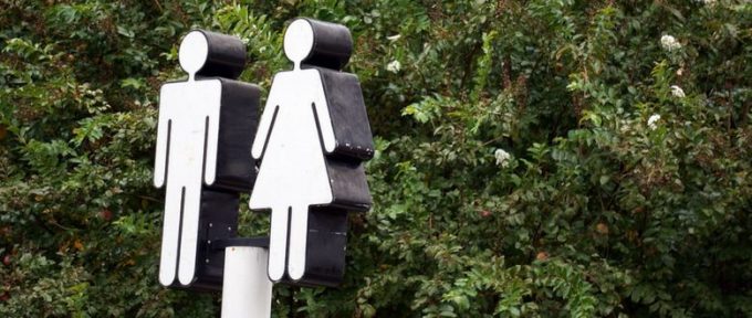 toilet sign in front of trees