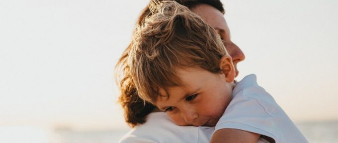parent hugging young child and smiling