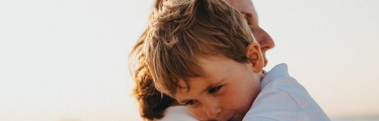 parent hugging young child and smiling