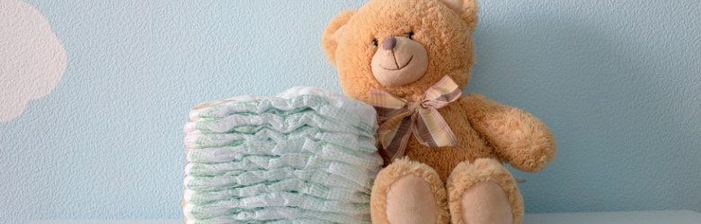 teddy bear beside pile of disposable nappies