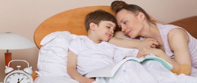 mother and son in bed with a book