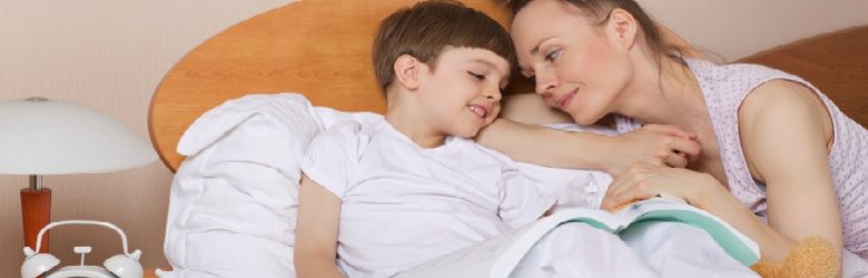 mother and son in bed with a book