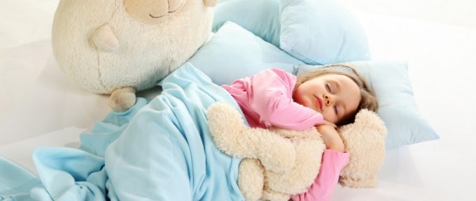 5 year old girl in bed with her cuddly soft toys