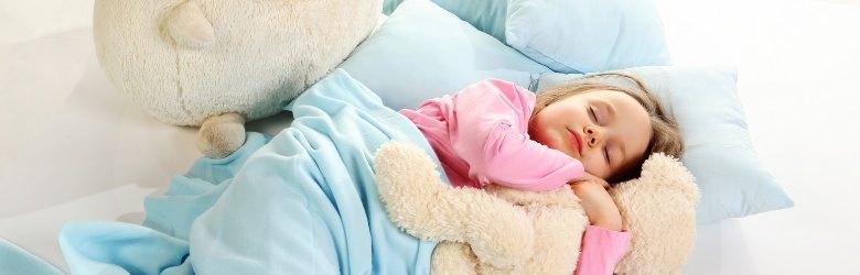 5 year old girl in bed with her cuddly soft toys