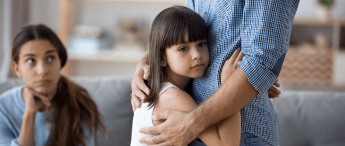 girl looking worried hugging her father