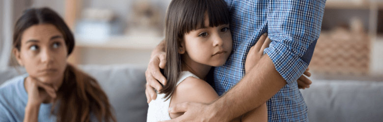 girl looking worried hugging her father