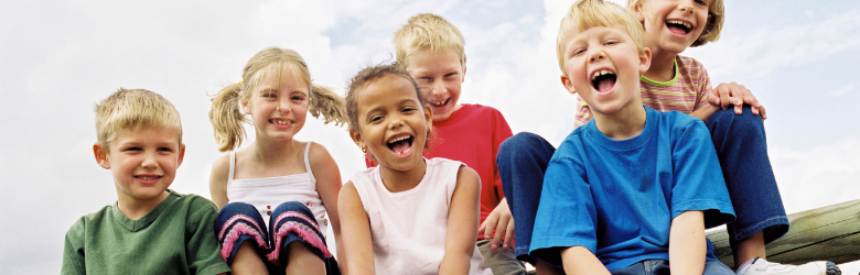 A group of young children smiling to illustrate that treatment is available for bedwetting