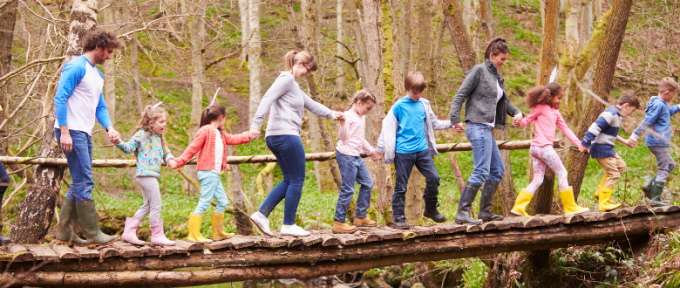 Group of Adults and Children walking along a tree