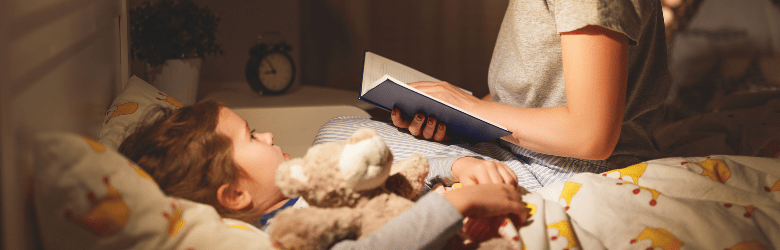 child in bed with mum reading a bed time story