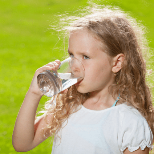 child drinking water from a glass