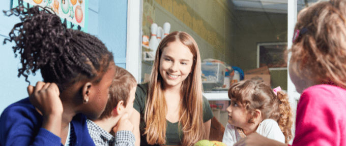 children with adult at table with fruit