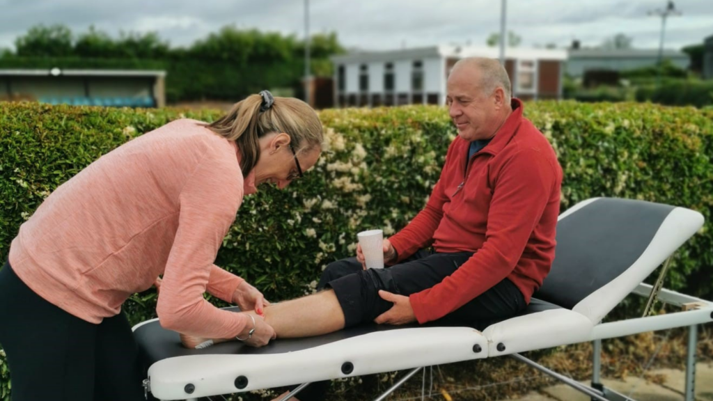 An image of one of the veterans being massaged on his leg after a day of walking