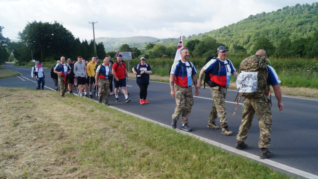 An image of the veterans on their journey walking along a road in the countryside 