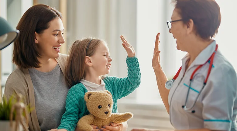 a nurse and child giving each other a high five